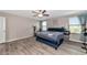 Main bedroom with large bed, hardwood floors, and ensuite bathroom at 7404 Mill Hopper Ct, Palmetto, FL 34221