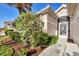 Welcoming front entrance with lush landscaping and a decorative screen door at 8472 Gateway Ct, Englewood, FL 34224
