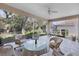 Spacious screened-in porch with wicker furniture and ceiling fan at 8472 Gateway Ct, Englewood, FL 34224