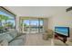 Living room with large windows, offering a view of the golf course at 1065 Gulf Of Mexico Dr # 201, Longboat Key, FL 34228