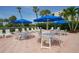 Outdoor patio with tables, chairs, and blue umbrellas at 1065 Gulf Of Mexico Dr # 201, Longboat Key, FL 34228