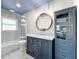 Modern bathroom with a marble vanity, blue cabinets, and a herringbone tile shower at 161 Sandhurst Dr, Venice, FL 34293