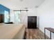 Main bedroom with barn door to en-suite bathroom and wood-look floors at 161 Sandhurst Dr, Venice, FL 34293