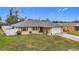 Tan one-story house with gray roof, white fence, and driveway at 161 Sandhurst Dr, Venice, FL 34293