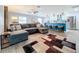 Open concept living room and kitchen with gray sectional sofa and area rug at 161 Sandhurst Dr, Venice, FL 34293