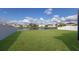 Spacious backyard with lush green grass, a serene pond, and a secure fence at 341 Grande Vista Blvd, Bradenton, FL 34212