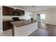 Bright kitchen featuring dark wood cabinets, a center island, and a view to the outdoor patio at 341 Grande Vista Blvd, Bradenton, FL 34212