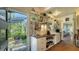 Charming kitchen features white cabinets, a view of a screened porch, and open shelving at 2525 Ashton Rd, Sarasota, FL 34231