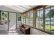 Sunroom showcasing a tiled floor, wicker bench, and serene garden views at 2525 Ashton Rd, Sarasota, FL 34231