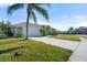 Single-story home with white garage door and palm trees at 5755 Carriage Dr, Sarasota, FL 34243