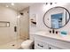 Elegant bathroom with a walk-in shower and round mirror at 6506 Gulf Dr, Holmes Beach, FL 34217