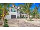 Two-story home with white siding, dark trim, and a brick driveway at 6506 Gulf Dr, Holmes Beach, FL 34217