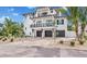 Modern two-story house with dark gray garage doors and tropical landscaping at 6506 Gulf Dr, Holmes Beach, FL 34217