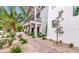 Brick pathway leads to home's entrance, tropical landscaping surrounds the property at 6506 Gulf Dr, Holmes Beach, FL 34217