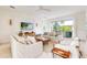 Open concept living area with stylish sofas and access to a balcony at 6506 Gulf Dr, Holmes Beach, FL 34217