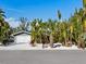 Gray house with white garage door and tropical landscaping at 671 Emerald Harbor Dr, Longboat Key, FL 34228