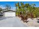 White garage door and driveway of a gray house at 671 Emerald Harbor Dr, Longboat Key, FL 34228