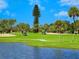 Golf course with lush greens, water features, and players enjoying a sunny day at 671 Emerald Harbor Dr, Longboat Key, FL 34228