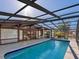 Lush landscaping surrounds this screened-in pool and patio area at 671 Emerald Harbor Dr, Longboat Key, FL 34228