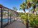Brick patio, screened pool, and lush tropical landscape at 671 Emerald Harbor Dr, Longboat Key, FL 34228