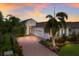 Mediterranean-style home with a three-car garage and lush landscaping at 7115 Callander Cv, Lakewood Ranch, FL 34202