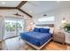 Main bedroom with king-size bed, private balcony, and wood-look floors at 9403 Gulf Dr, Anna Maria, FL 34216