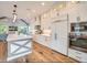 Open kitchen with white shaker cabinets, a large island, and quartz countertops at 9403 Gulf Dr, Anna Maria, FL 34216