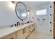Elegant bathroom with double vanity and large round mirror at 9407 Gulf Dr, Anna Maria, FL 34216
