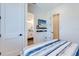 Bedroom with built-in shelving, TV, and ensuite bathroom at 9407 Gulf Dr, Anna Maria, FL 34216