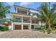 Two-story home with a modern design, two-car garage, and lush landscaping at 9407 Gulf Dr, Anna Maria, FL 34216