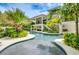 Luxury two-story home with pool, expansive patio, and tropical landscaping at 9407 Gulf Dr, Anna Maria, FL 34216