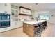 Spacious kitchen with white cabinetry, wood island, and stainless steel appliances at 9407 Gulf Dr, Anna Maria, FL 34216