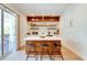 Modern kitchenette with white cabinets, wood shelving, and breakfast bar at 9407 Gulf Dr, Anna Maria, FL 34216