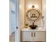 Stylish powder room with a round mirror and vessel sink at 9407 Gulf Dr, Anna Maria, FL 34216