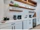 Stylish wet bar featuring white cabinets and wood shelving at 9407 Gulf Dr, Anna Maria, FL 34216