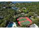 Aerial view shows tennis courts, pool, and marina in a lush setting at 1709 Pelican Cove Rd # Gl445, Sarasota, FL 34231