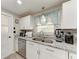Kitchen featuring stainless steel appliances, granite countertops, white cabinets, and modern fixtures at 1777 Pomelo Dr, Venice, FL 34293