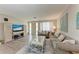 Bright living room with wood floors, neutral paint, comfortable furniture, and a decorative area rug at 1777 Pomelo Dr, Venice, FL 34293