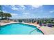 Community pool with scenic water views and patio furniture at 258 Golden Gate Pt # 801, Sarasota, FL 34236