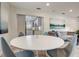 Modern dining area with white round table and four blue chairs, open to living room at 730 40Th St, Sarasota, FL 34234