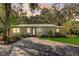 Newly renovated home with a metal roof, paved driveway, and landscaped yard at 730 40Th St, Sarasota, FL 34234