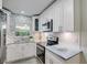 Modern kitchen with white cabinets, stainless steel appliances, and patterned backsplash at 730 40Th St, Sarasota, FL 34234