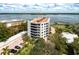 Aerial view of waterfront condo building with parking and pool at 8701 Midnight Pass Rd # 106A, Sarasota, FL 34242