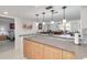 Open kitchen with breakfast bar, granite countertops, and light wood cabinets at 8701 Midnight Pass Rd # 106A, Sarasota, FL 34242