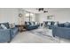 Spacious living room featuring blue sofas, coffee table, and large windows at 8701 Midnight Pass Rd # 106A, Sarasota, FL 34242