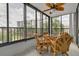Bright sunroom with wicker furniture and large windows offering an outdoor view at 8701 Midnight Pass Rd # 106A, Sarasota, FL 34242