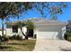 Charming single-story home featuring a well-maintained lawn, a two-car garage, and lovely palm trees in the front yard at 12147 Maple Ridge Dr, Parrish, FL 34219
