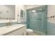 Bathroom with white vanity, light blue tiled shower, and modern fixtures at 1302 58Th W St, Bradenton, FL 34209