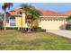 Beautiful yellow house with a tile roof, palm trees, and a landscaped lawn at 6854 Wagon Wheel Cir, Sarasota, FL 34243