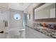 Bathroom with granite countertop, white cabinets, and a bathtub at 1325 Siesta Bayside Dr # 1325B, Sarasota, FL 34242